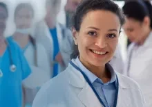 A group of medical professionals look on with a doctor in front.